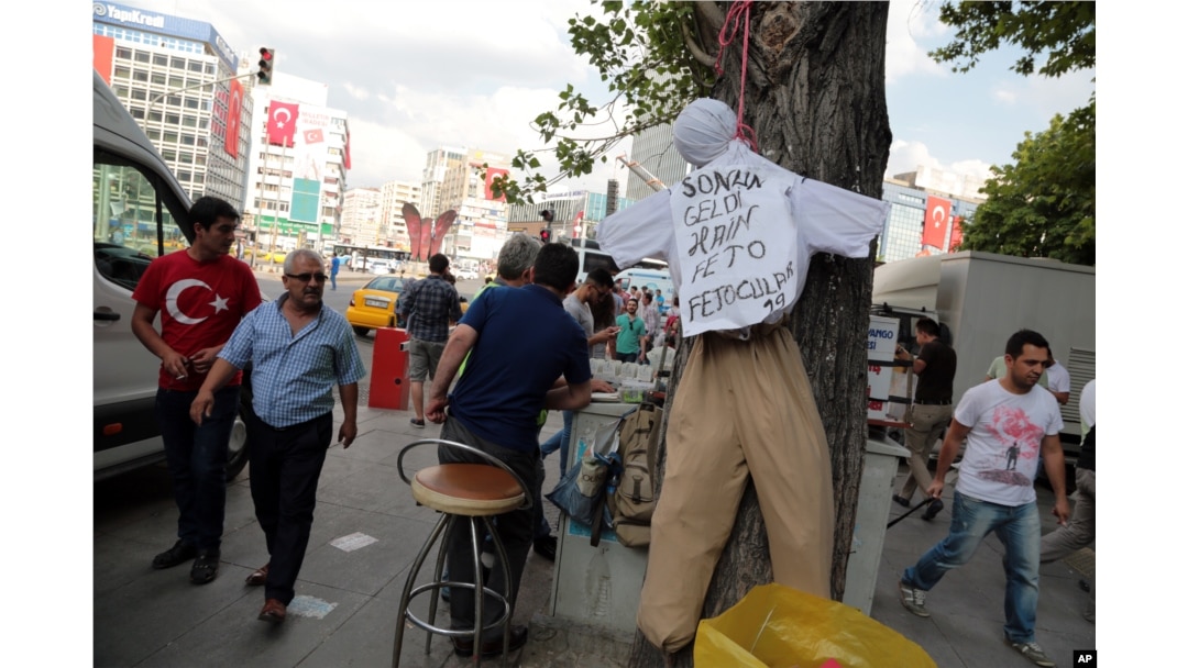 People pass by an effigy of Fethullah Gulen, a U.S.-based Muslim cleric, with Turkish words that read: "the traitor, FETO " (Feto is the nickname of Fethullah Gulen) in Ankara, Turkey, July 21, 2016.