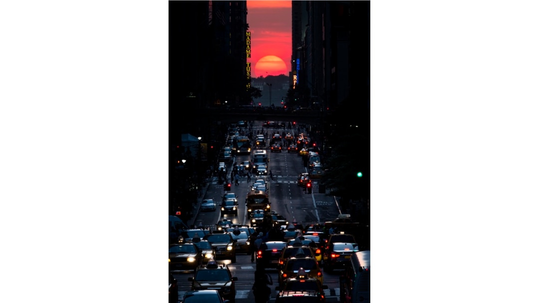 FILE - The sun sets along 42nd Street in Manhattan on May 29, 2013, in New York. (AP Photo/John Minchillo)