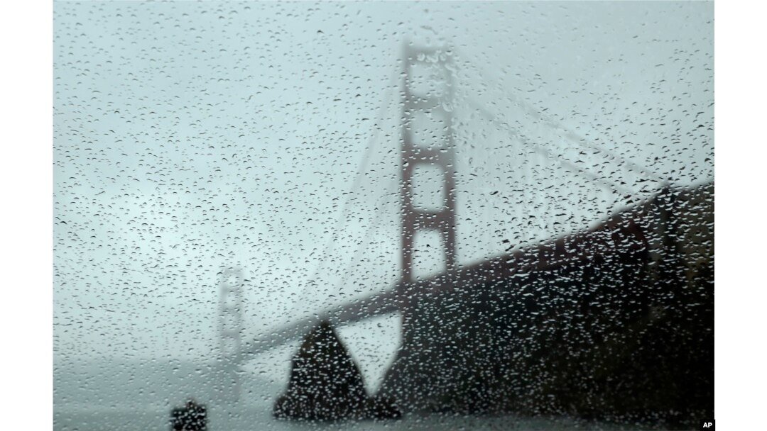 FILE - Rain drops bead on a car window below the Golden Gate Bridge, Jan. 5, 2016, in Sausalito, Calif. El Nino storms lined up in the Pacific, promising to drench parts of the West for more than two weeks.
