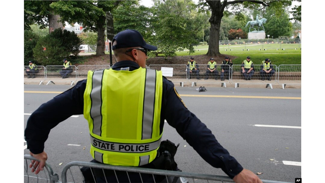 State Police patrol the road in front of Market Street park with the statue of Confederate General Robert E. Lee as they lock down the downtown area in anticipation of the anniversary of last year's Unite the Right rally in Charlottesville, Va., Aug. 11, 2018.