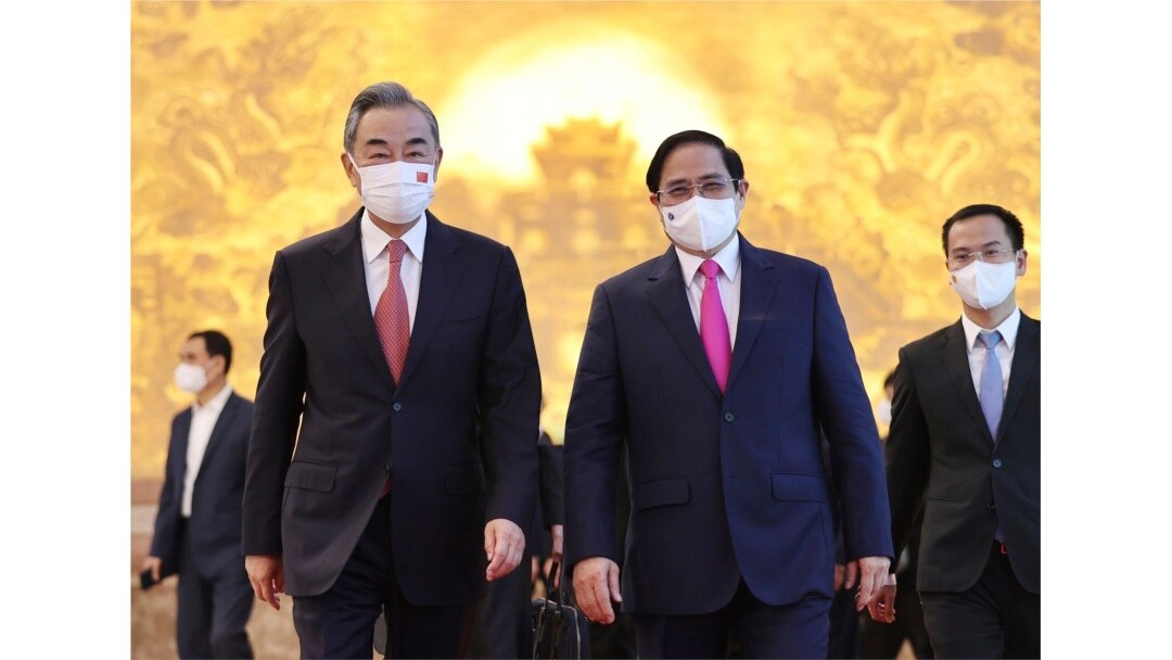 Vietnamese Prime Minister Pham Minh Chinh (R) and Chinese Foreign Minister Wang Yi (L) walk into meeting room in Hanoi, Vietnam, Sep.11, 2021.