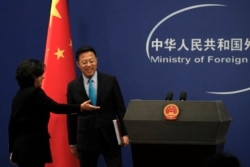 中國外交部發言人華春瑩引導新任發言人趙立堅走入例行記者會會場。 （2020年2月24日）