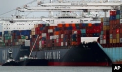 FILE - The Yang Ming shipping line container ship Ym Utmost is unloaded at the Port of Oakland, July 2, 2018, in Oakland, Calif. The Trump administration on July 6, 2018, began imposing tariffs on $34 billion in Chinese imports.