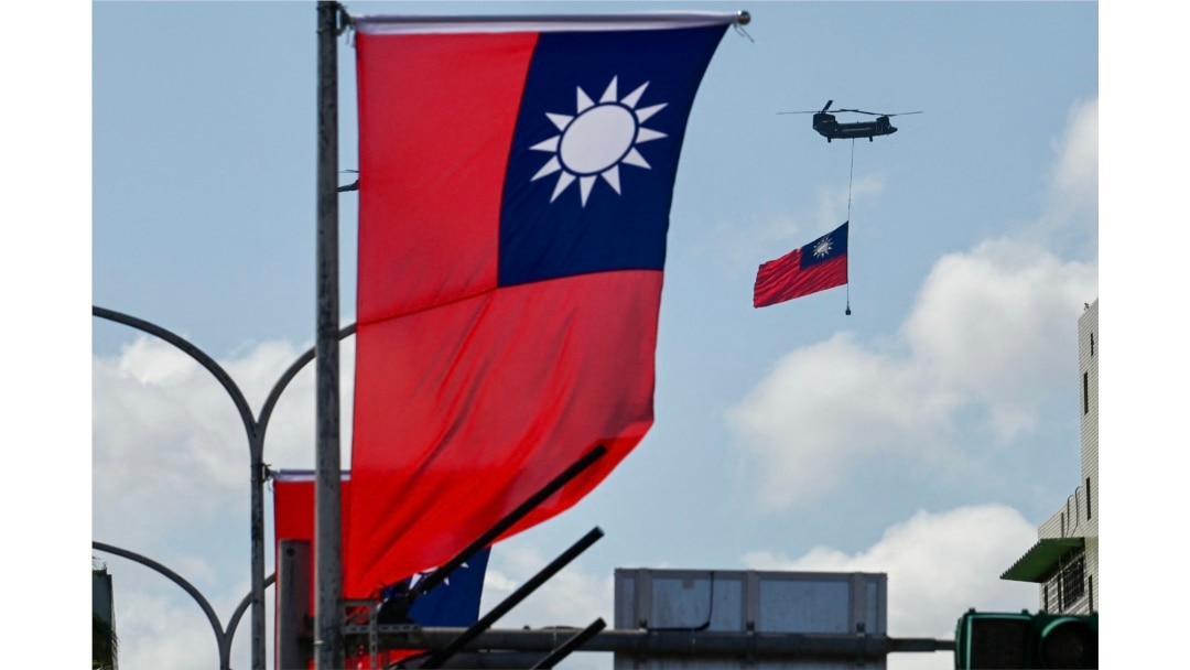 FILE - A CH-47 Chinook helicopter carries a Taiwan flag during national day celebrations in Taipei on Oct. 10, 2021.