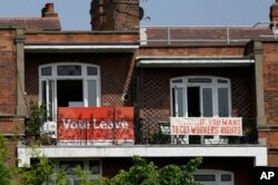 FILE - Banners of opposing views on Britain's so-called Brexit referendum on EU membership are displayed on the balconies of two neighboring apartments in the Gospel Oak area of north London, May 27, 2016.