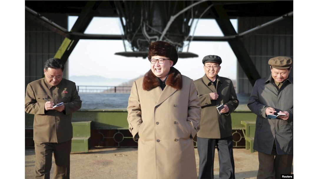 North Korea leader Kim Jong Un smiles as he visits Sohae Space Center in Cholsan County, North Pyongan province for the testing of a new engine for an intercontinental ballistic missile in this undated photo.