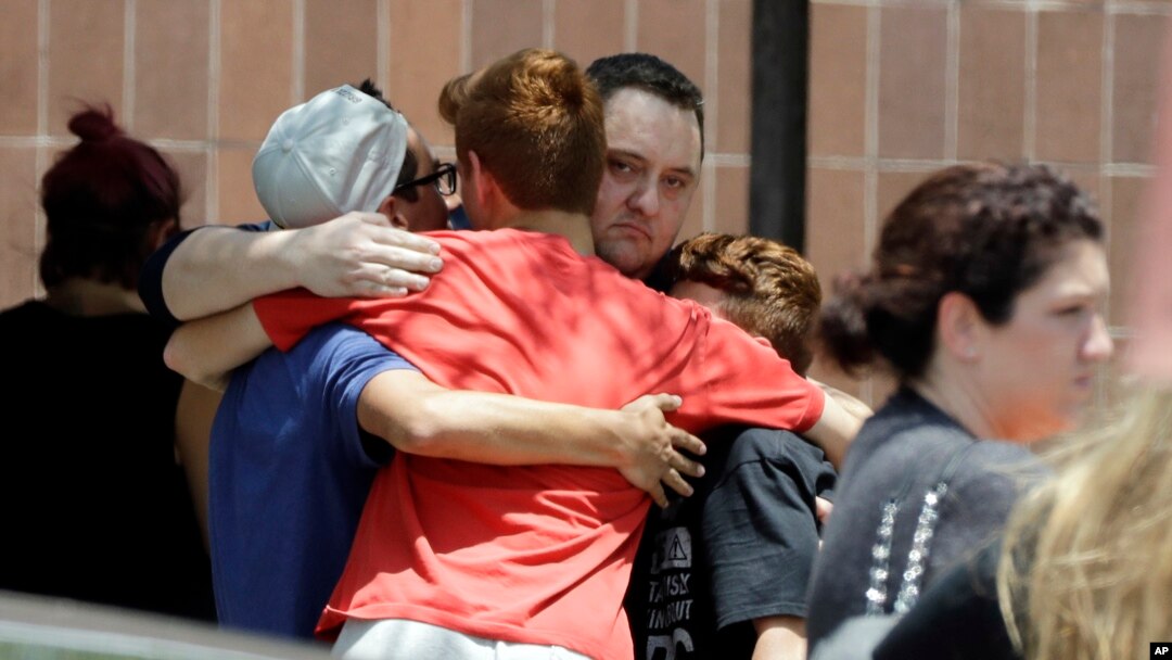People react outside the unification center at the Alamo Gym, following a shooting at Santa Fe High School in Santa Fe, Texas.