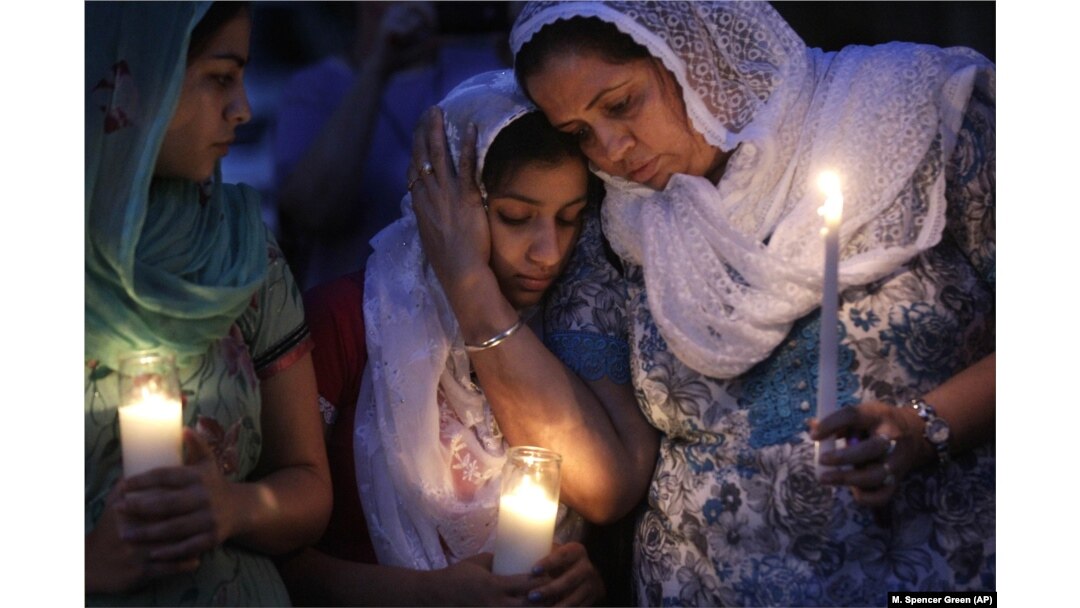In this Monday, August 6, 2012 file photo, Sikh worshipers gather for a candlelight vigil after prayer services at the Sikh Religious Society of Wisconsin in Brookfield, Wisconsin.