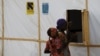 FILE - A woman and a girl are seen outside makeshift accommodations at Bakassi Camp for internally displaced people in Maiduguri, Nigeria, March 8, 2016.