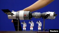 資料照： 在酒泉衛星發射中心展示的中國神舟9號飛船與三名中國宇航員的模型。 （2012年6月15日）