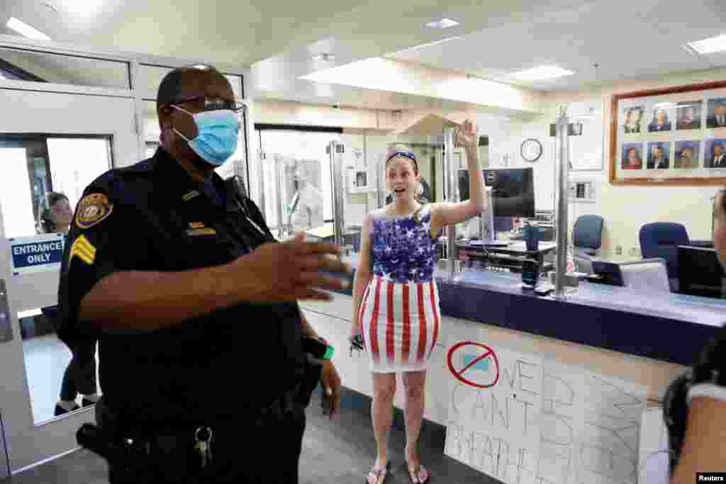 A parent and a member of the 'Community Patriots' confronts a police officer while protesting against wearing masks in schools at the Pinellas County Schools Administration Building in Largo, Florida, Aug. 9, 2021.