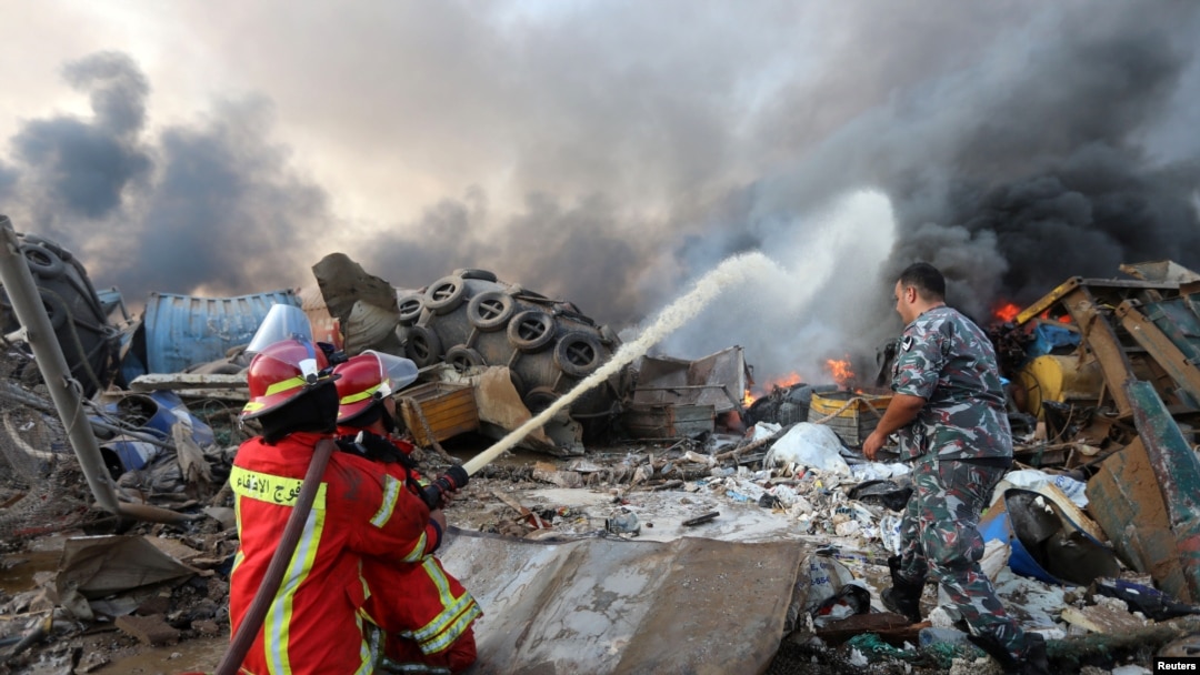 Firefighters spray water on a fire following an explosion in Beirut's port area, Lebanon, Aug. 4, 2020. 