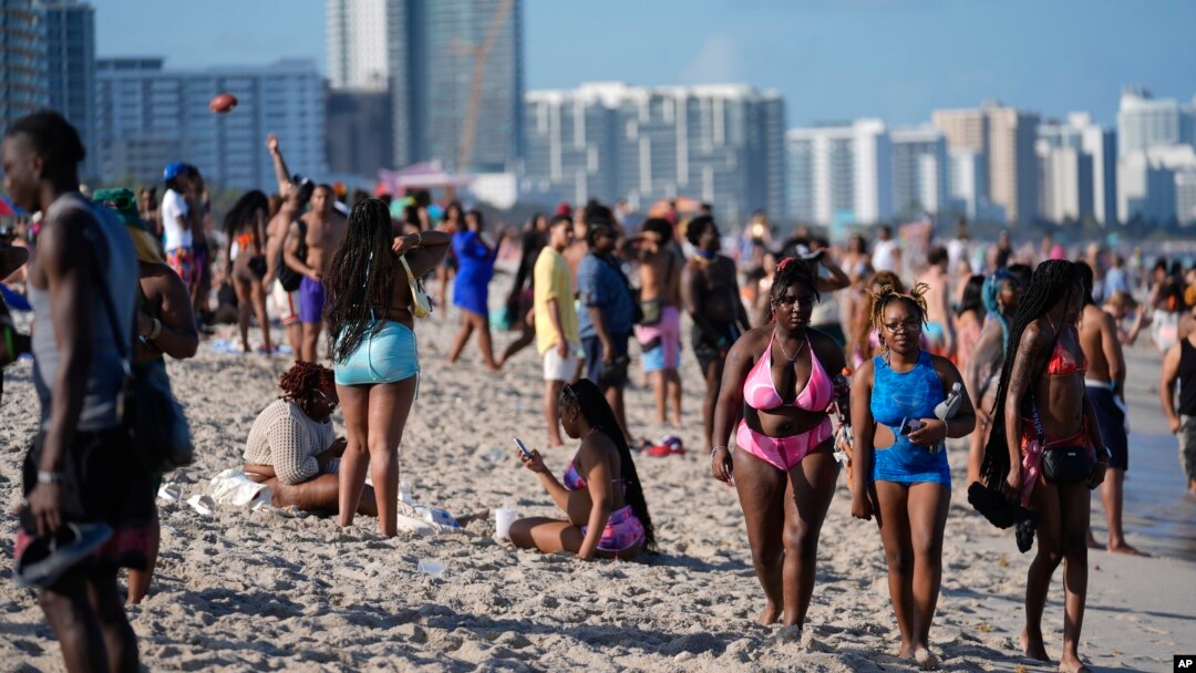 ARCHIVO - Turistas y residentes de Miami Beach caminan por la playa el viernes 15 de marzo de 2024, en medio de las vacaciones de primavera.