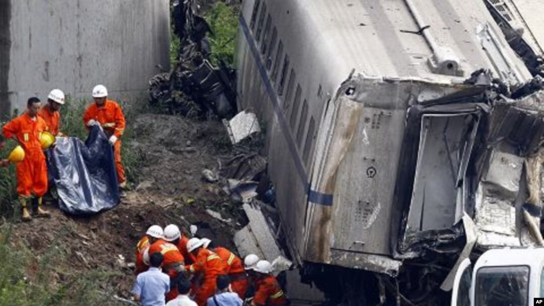 Rescuers carry a body of a victim discovered among the wreckage after two carriages from a bullet train derailed and fell off a bridge in Wenzhou, Zhejiang province, China, July 24, 2011