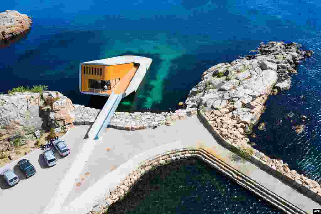 This photo shows an aerial view of Under, a restaurant that is semi-submerged beneath the waters of the North Sea in Lindesnes near Kristiansand, some 400 km south west of Oslo. The new restaurant serves up Poseiden's delicacies with a unique view, in an architectural showpiece that stretches five meters (15 feet) underwater. The restaurant is a 34-meter monolith designed by Norwegian firm Snohetta, known for its celebrated buildings such as the Oslo Opera and the 9/11 Memorial Pavilion in New York.
