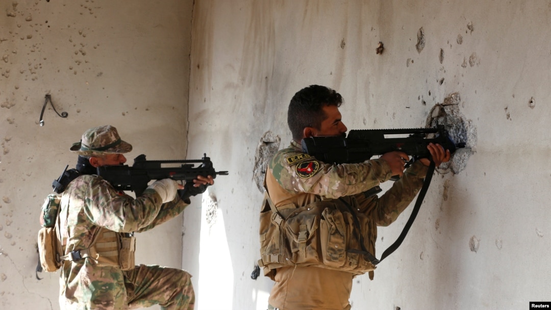Iraqi security forces take cover during clashes with Islamic State militants, north of Mosul, Iraq, Dec. 30, 2016.
