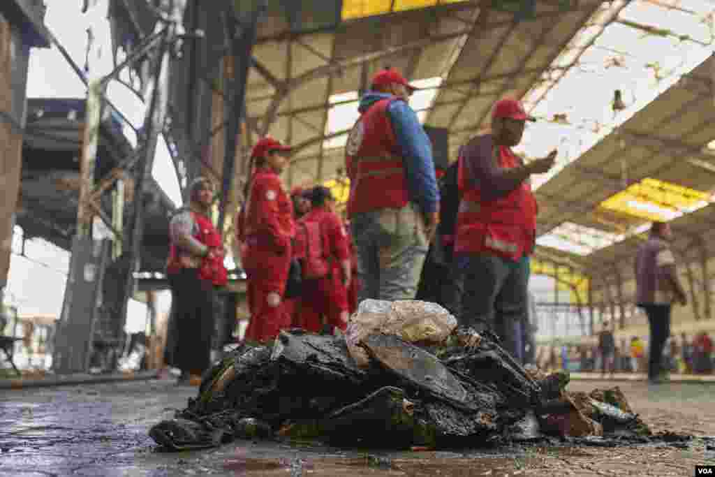 As crews work to clear the soaked, charred wreckage, paramedics stand by for instructions after tending to victims. At least 25 died and dozens injured in the crash, Feb. 27, 2019. (H. Elrasam/VOA)