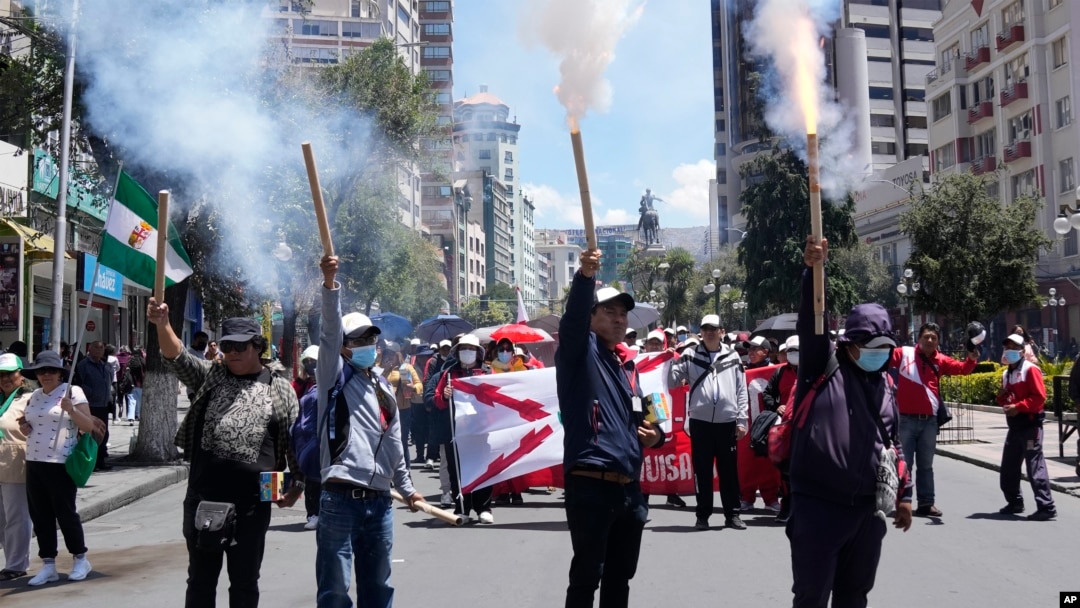 Profesores con fuegos artificiales durante una protesta de maestros para exigir un aumento de salarios y el rechazo al nuevo currículum escolar en escuelas públicas, en La Paz, Bolivia el lunes 6 de marzo de 2023. 