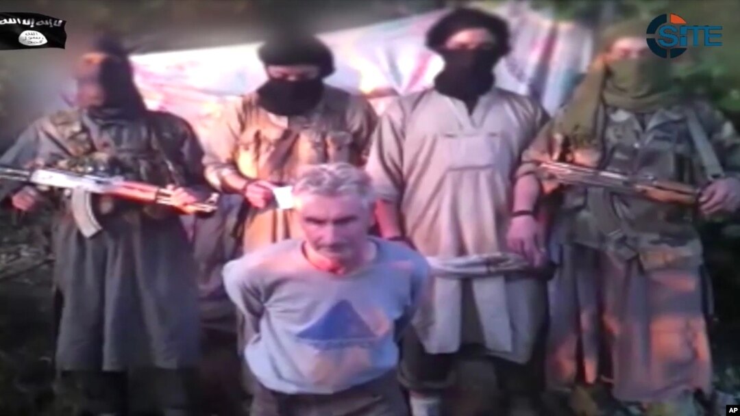 Imágen del video publicado en internet en que aparecen miembros del grupo Soldados del califato con el rehén francés, Herve Gourdel.