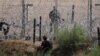 Un migrante que busca asilo en Estados Unidos es vigilado por un miembro de la Guardia Nacional de Texas después de cruzar el río Grande, visto desde Ciudad Juárez, estado de Chihuahua, México, el 5 de junio de 2024.