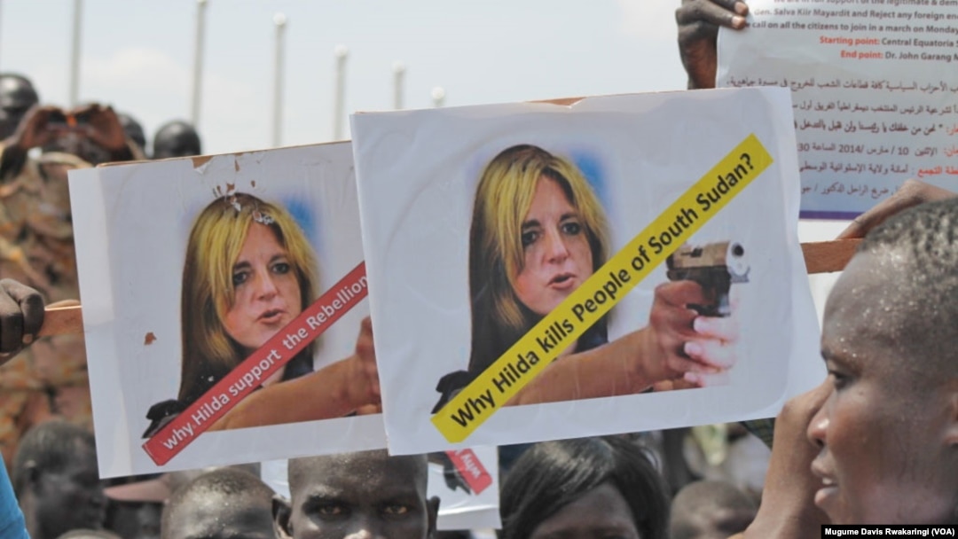 A protester holds up signs protesting against UNMISS head Hilde Johnson at a rally in Juba after South Sudanese government forces found weapons in a UN overland shipment.