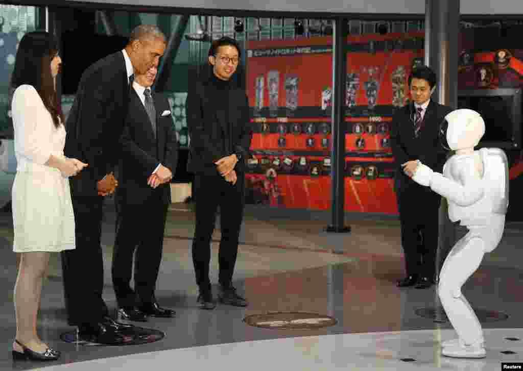 U.S. President Barack Obama (2nd L) bows to "Asimo" the robot while visiting Miraikan or the National Museum of Emerging Science and Innovation, in Tokyo, Japan.