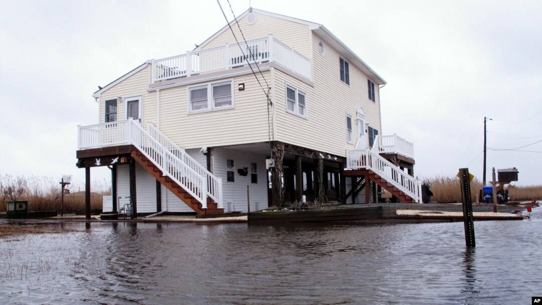 FILE - This March 14, 2017, photo shows Jim and Maryann O'Neill's home in a back bay neighborhood of Manahawkin, N.J., surrounded by water after a moderate storm.