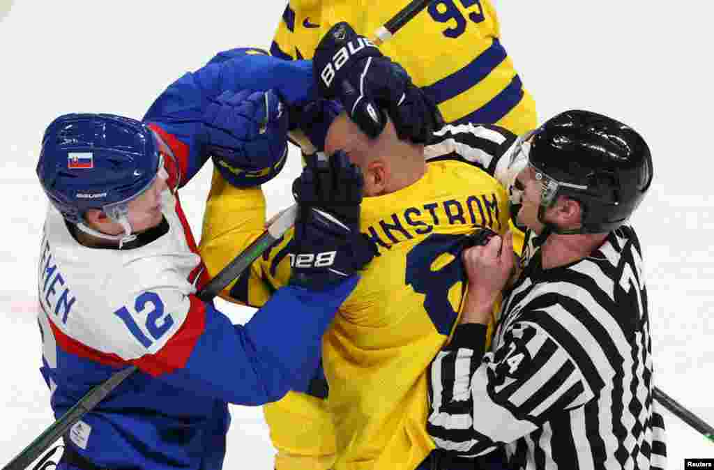 Milos Kelemen of Slovakia and Theodor Lennstrom of Sweden clash during men's ice hockey at the 2022 Beijing Olympics, Wukesong Sports Centre, Beijing, China.