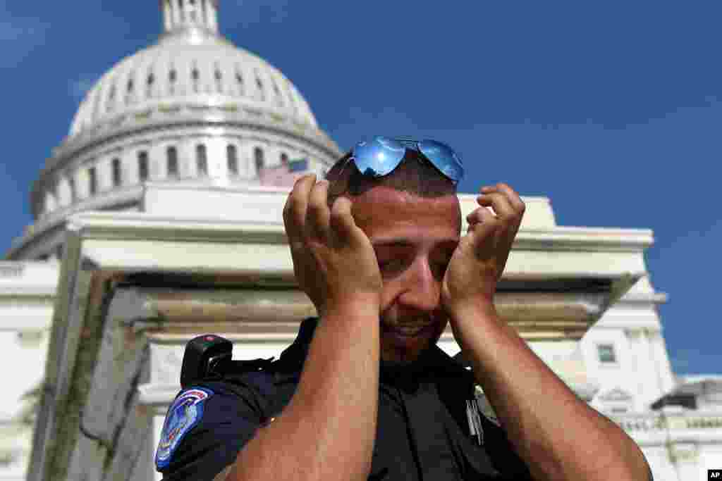 A Capitol Hill police officer wipes sweat from his eyes as he stands his post on the West side of Capitol Hill in Washington, D.C., July 20, 2019. The National Weather Service said "a dangerous heat wave" was expected to break record highs in some places, particularly for nighttime.
