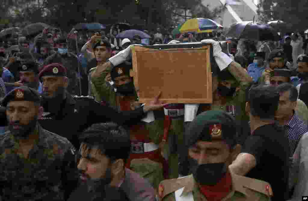 Soldiers carry the national flag-wrapped casket of Pakistani nuclear scientist Abdul Qadeer Khan following his funeral prayer, in Islamabad. Khan, a controversial figure known as the father of Pakistan's nuclear bomb, died Sunday of COVID-19 following a lengthy illness, his family said. He was 85.