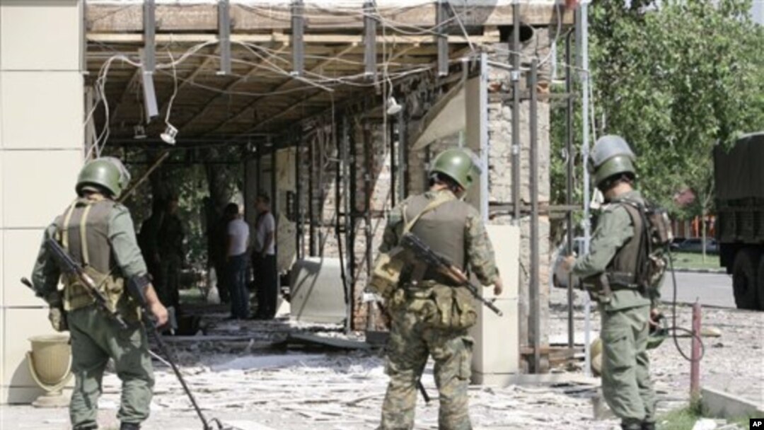 Security personnel stand guard at scene of suicide bombings in central Grozny, Chechnya, Aug. 31, 2011