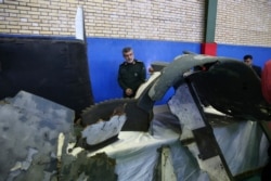 Head of the Revolutionary Guard's aerospace division Gen. Amir Ali Hajizadeh looks at debris from what the division describes as the U.S. drone which was shot down on Thursday, in Tehran, Iran, June 21, 2019.