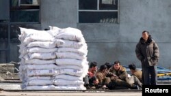 지난 3월 중국 단둥에서 압록강 넘어로 바라본 북한 신의주에 비료 더미가 쌓여있다.