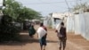 FILE - Men carry bags of food aid at the Kakuma refugee camp in northern Kenya, March 6, 2018. 