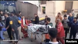 Timu ya Shirika la Mwezi Mwekundu la Palestina likiwafikisha waliouawa katika hospitali ya Al-Awda, huko Jabalia, Ukanda wa Gaza.