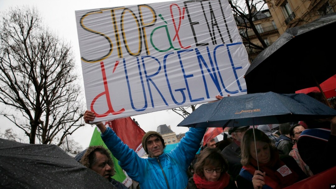 A protester holds a banner reading " Stop of state of emergency" during a protest in Paris, Jan. 30, 2016.
