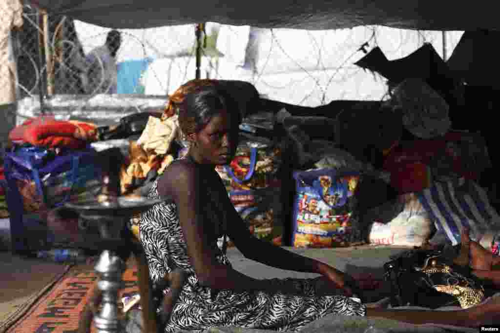 A South Sudanese woman sits in a tent in a camp for displaced persons in the United Nations Mission in South Sudan (UNMISS) compound in Tongping, Juba, Feb. 19, 2014. 