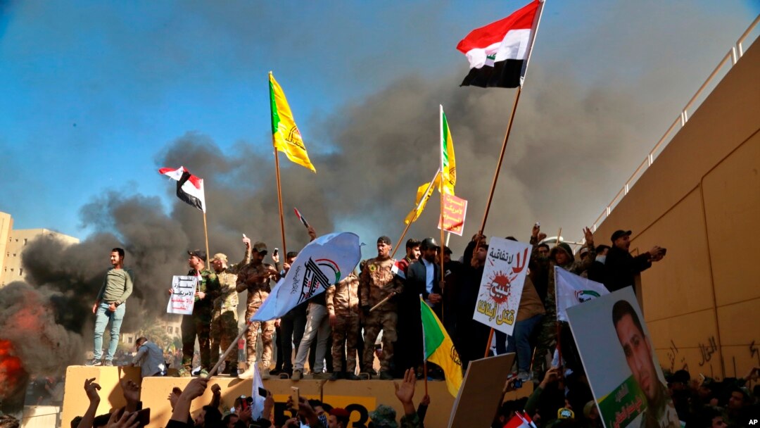 Protesters burn property in front of the U.S. embassy compound, in Baghdad, Iraq, Tuesday, Dec. 31, 2019. Dozens of angry Iraqi Shiite militia supporters broke into the U.S. Embassy compound in Baghdad on Tuesday. (AP Photo/Khalid Mohammed)