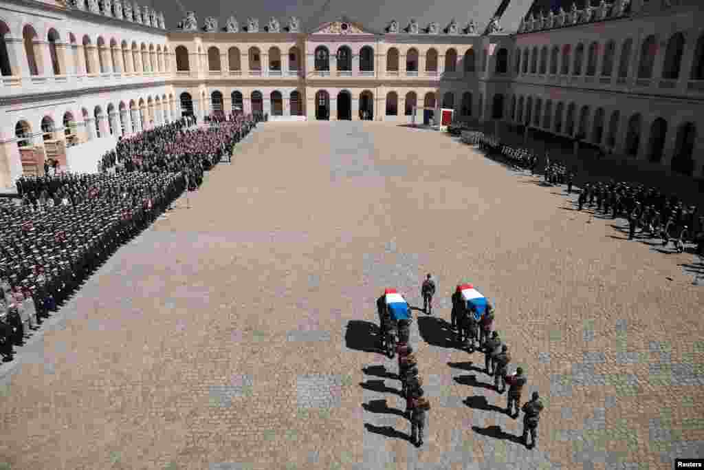 French soldiers of the Commando Hubert carry the flag-draped coffins during a national ceremony at the National Invalides Hotel in Paris, for the two French marine soldiers, Cedric de Pierrepont and Alain Bertoncello, killed during a hostage rescue operation in Burkina Faso.