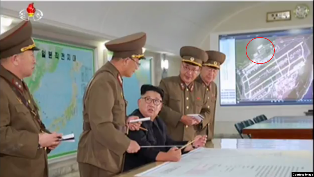 김정은 국무위원장 왼편 화면에 괌 앤더슨 공군기지 위성사진이 떠 있다. 원안 부분으로 이 사진이 2011년 찍힌 사실을 알 수 있다. 출처=조선중앙TV