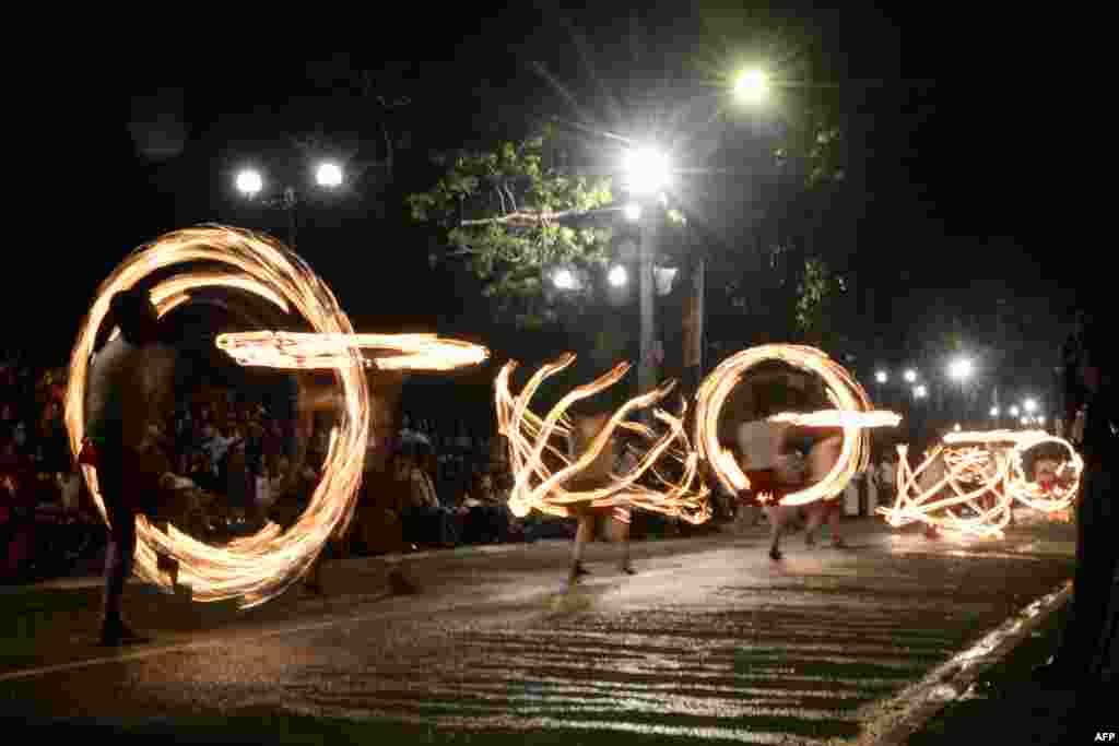 Fire-dancers perform during the "Esala Perahera" festival near the Buddhist temple of the Tooth in the ancient hill capital of Kandy, some 116 kilometers from Colombo, Sri Lanka, Aug. 14, 2019.