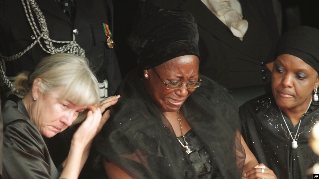 FILE - Wife of the late Zambian President Christine Kaseba Sata, center, is comforted at the funeral of her husband, Michael Sata, in Lusaka, Nov. 11, 2014. 