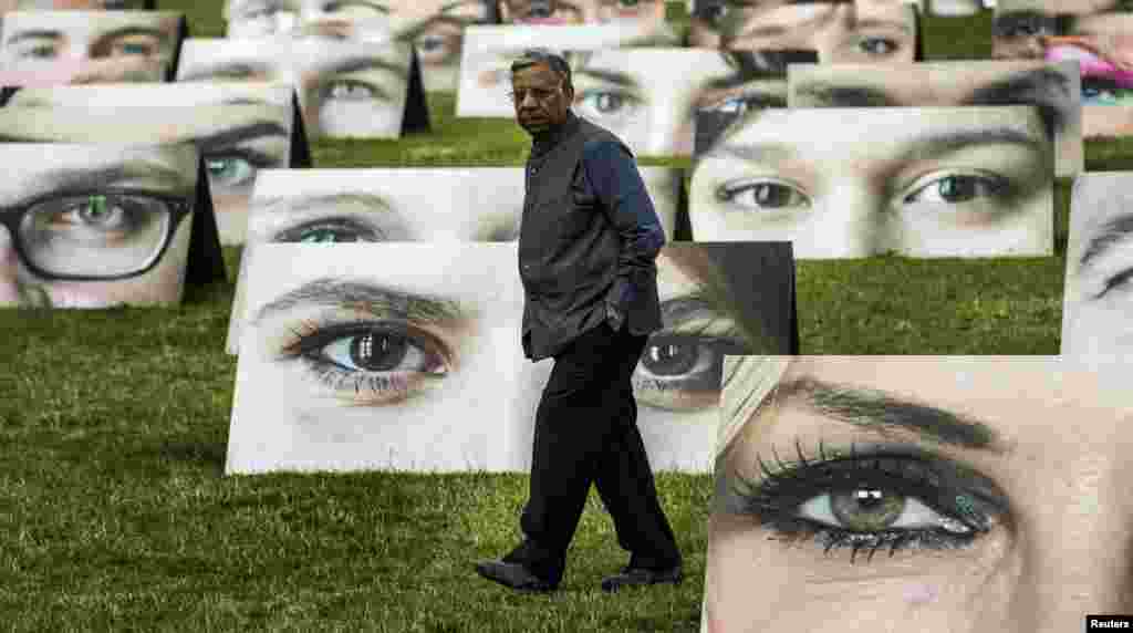 A man walks amidst cardboard displays that are part of an installation by One.org in Berlin. One.org set up 140 pictures with pairs of eyes trained at the Reichstag, the seat of Germany's lower house of parliament, to draw attention to the plight of the world's poor and symbolize the close attention people pay to the government's international development policies. 