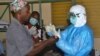 Health workers take off their protective suits as they finish their shifts at the Pita hospital, Guinea, Aug. 25, 2014. 