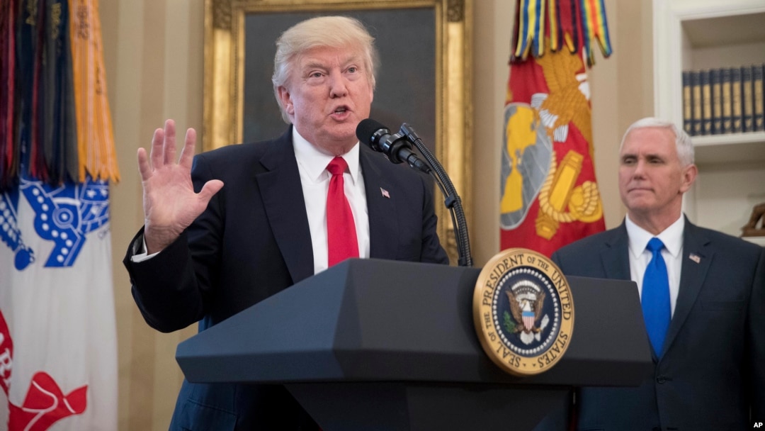 President Donald Trump, accompanied by Vice President Mike Pence, right, speaks during a signing ceremony for executive orders regarding trade in the Oval Office at the White House, March 31, 2017, in Washington. 