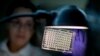 FILE - A microbiologist reads a panel to check on a bacterium's resistance to an antibiotic in the Infectious Disease Laboratory at the federal Centers for Disease Control and Prevention in Atlanta.