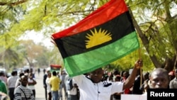 FILE - A supporter of Indigenous People of Biafra (IPOB) leader Nnamdi Kanu holds a Biafra flag during a rally in support of Kanu in Abuja, Nigeria, Dec. 1, 2015