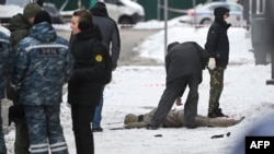 Investigadores e especialistas policiais trabalham junto a um corpo no local da explosão, que matou o comandante Igor Kirillov, e o seu assistente, 17 dezembro 2024