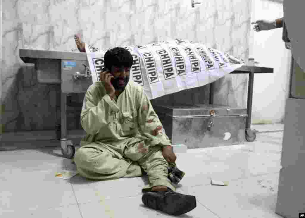 A man talks on his phone at a hospital in Quetta, Pakistan after a roadside bomb struck a security vehicle, killing at least four people.