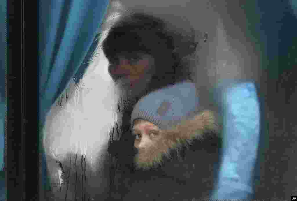 Una mujer y un niño al interior de un autobús mientras salen de Sievierodonetsk, en la región de Luhansk, en el este de Ucrania, el jueves 24 de febrero de 2022. 
